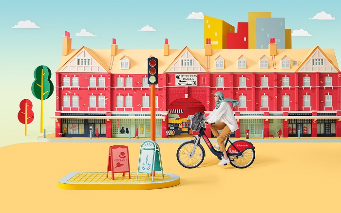 Person cycling on a Santander Cycle infront of a graphic of Spitalfields Market
